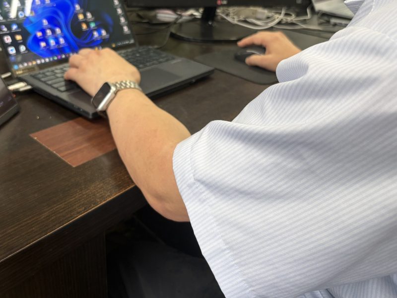 作業デスクでパソコンを操作している手元